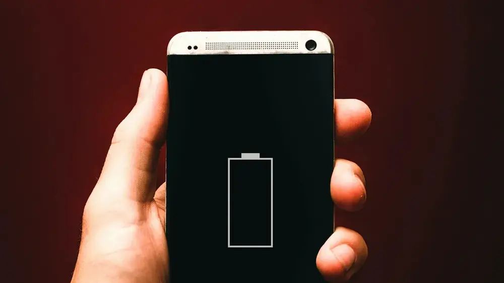 Elinde düşük pil uyarısı gösteren telefon tutan kişi