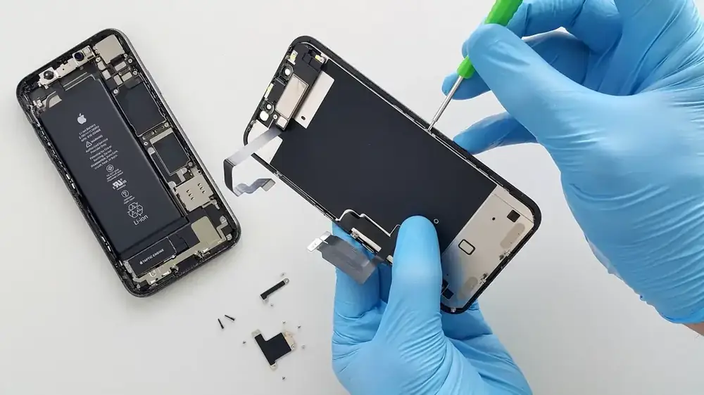 Eldivenle telefon bataryası değiştiren teknisyen