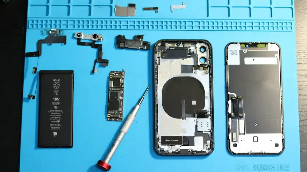 Mavi mat üzerinde sökülmüş iPhone parçaları